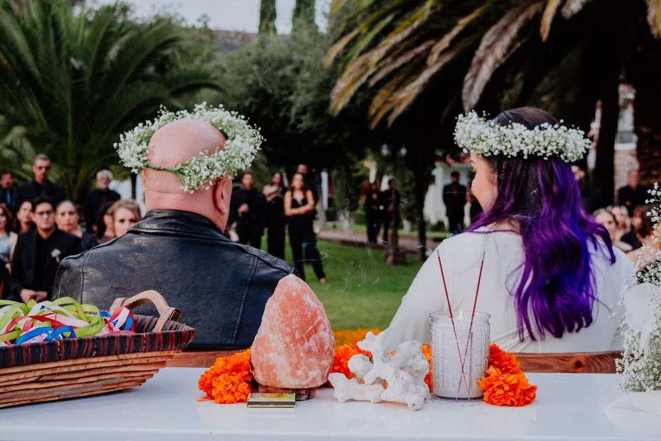 Novios de espaldas con coronas de flores