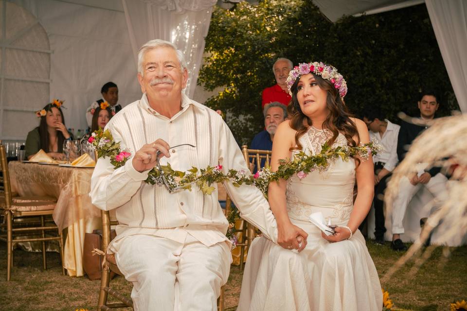 Pareja sentada unida con un lazo de flores