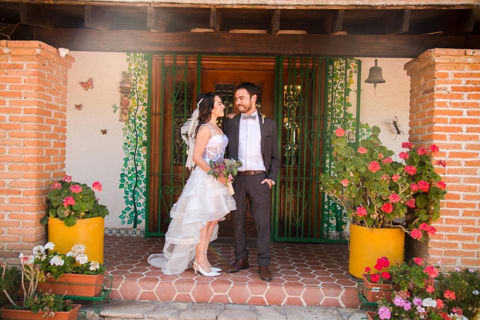 Novios posando en la entrada de la casa