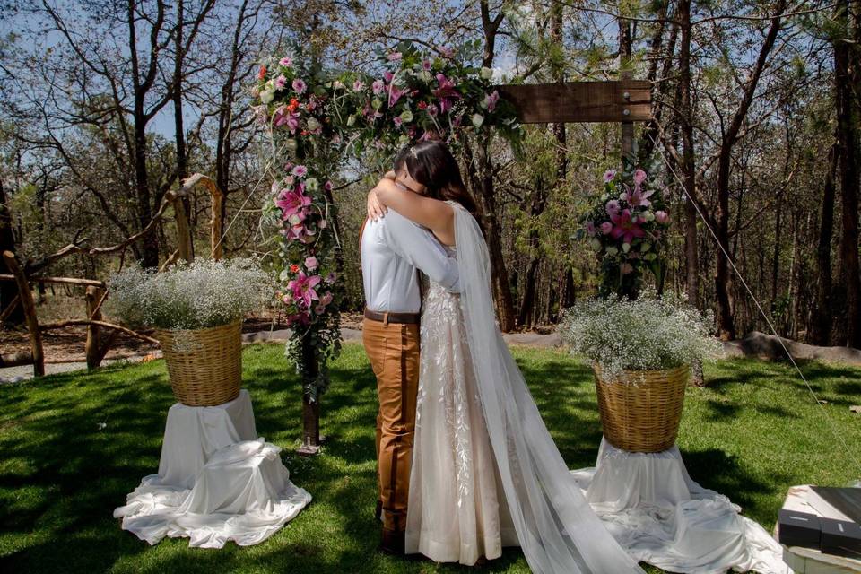 Novios abrazándose en un jardín con flores