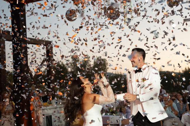 Novios bailando mientras caen papelitos