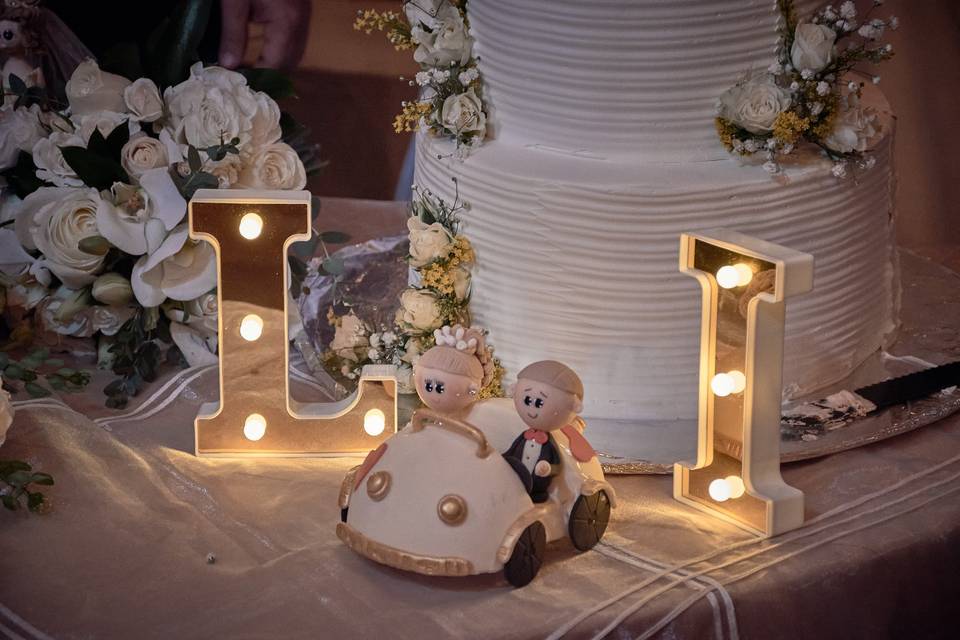 Cake topper de novios, pastel y letras iluminadas