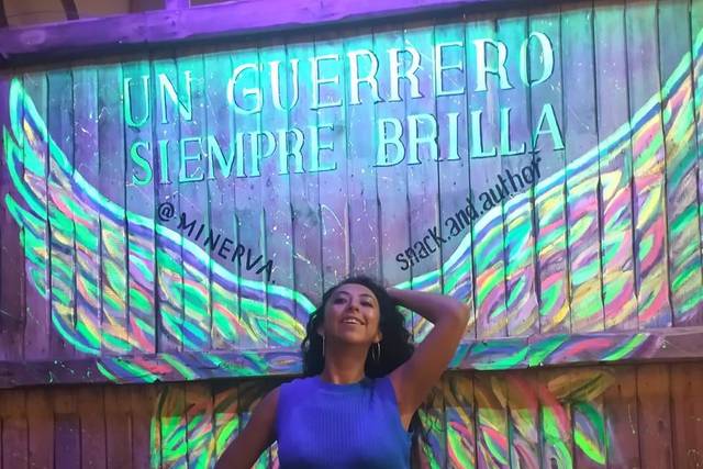 Mujer posando con una alas pintadas