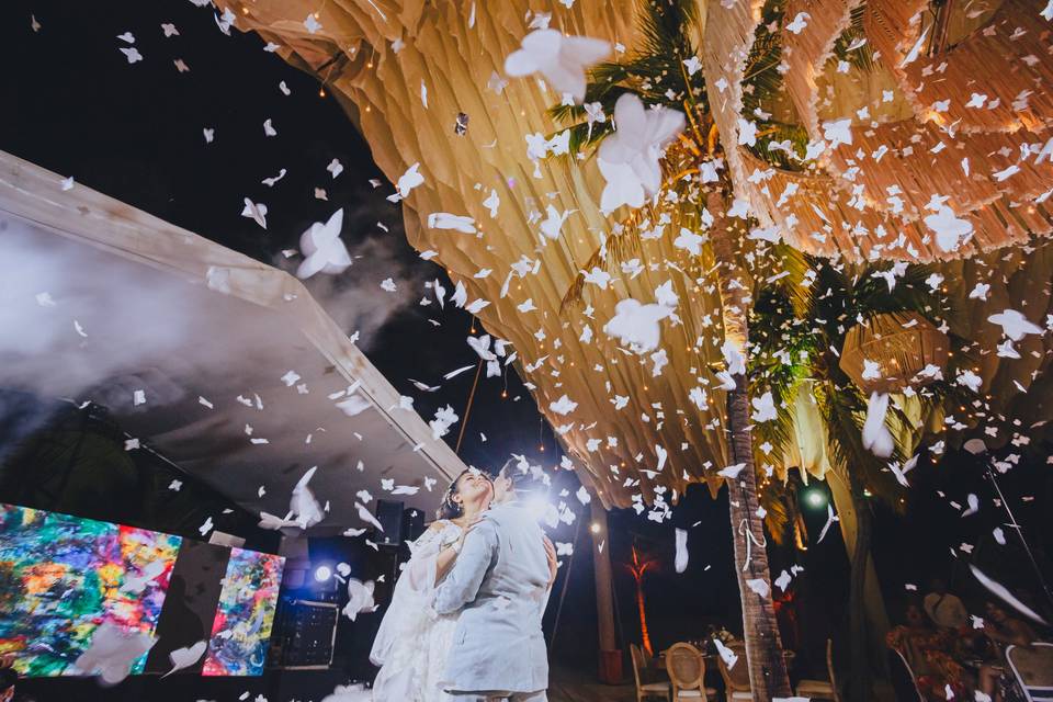 Novios en medio de la pista lloviendo espuma