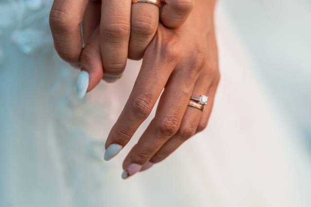 Manos entrelazadas con los anillos de matrimonio
