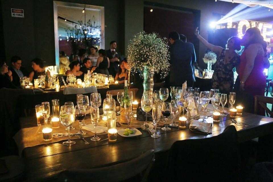 Mesa decorada con velas y copas de cristal