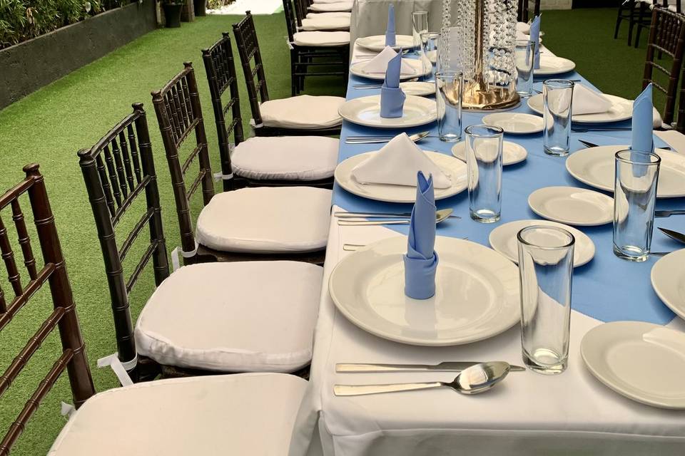 mesa con vajilla blanca y mantel azul claro