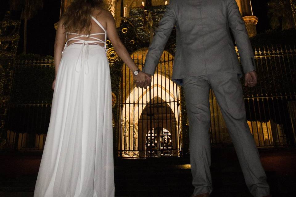 Novios tomados de la mano frente a una iglesia