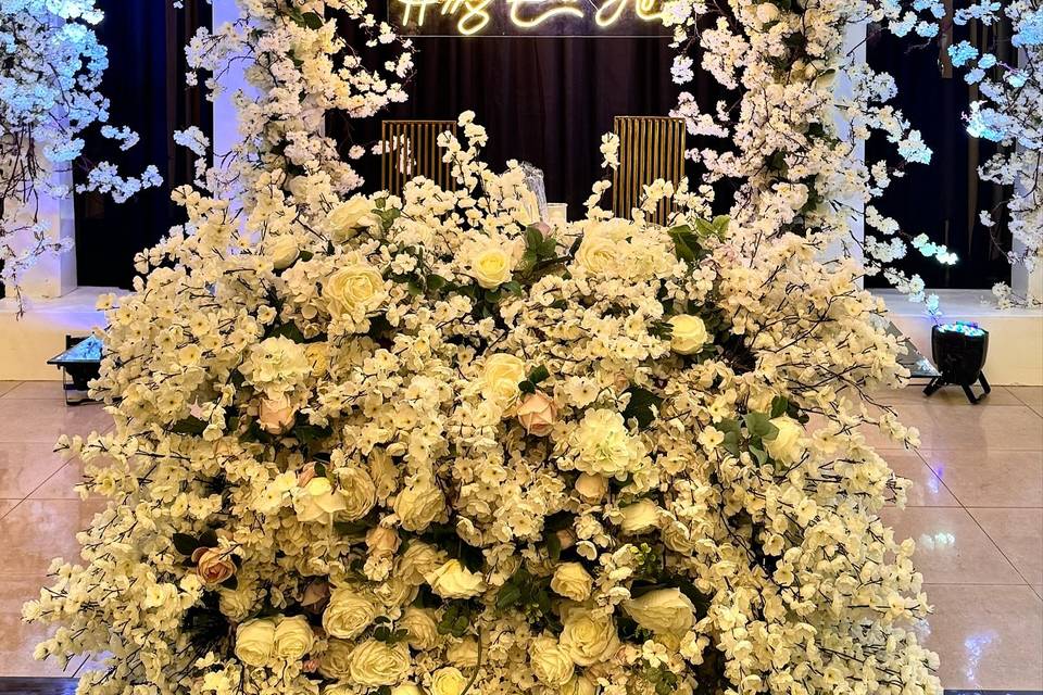 Decoración con flores blancas y letrero neón para evento