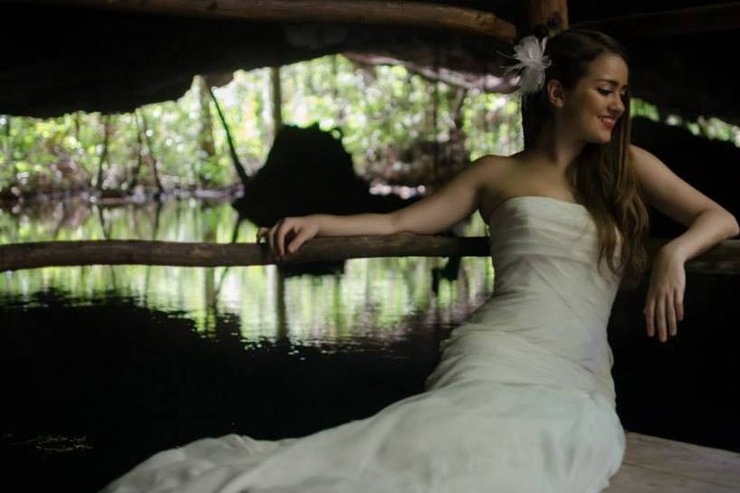 Novia posando sentada en un cenote