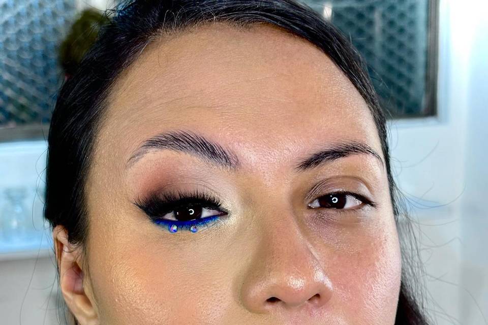 Pestañas postizas y ojo delineado en azul con piedras de fantasia