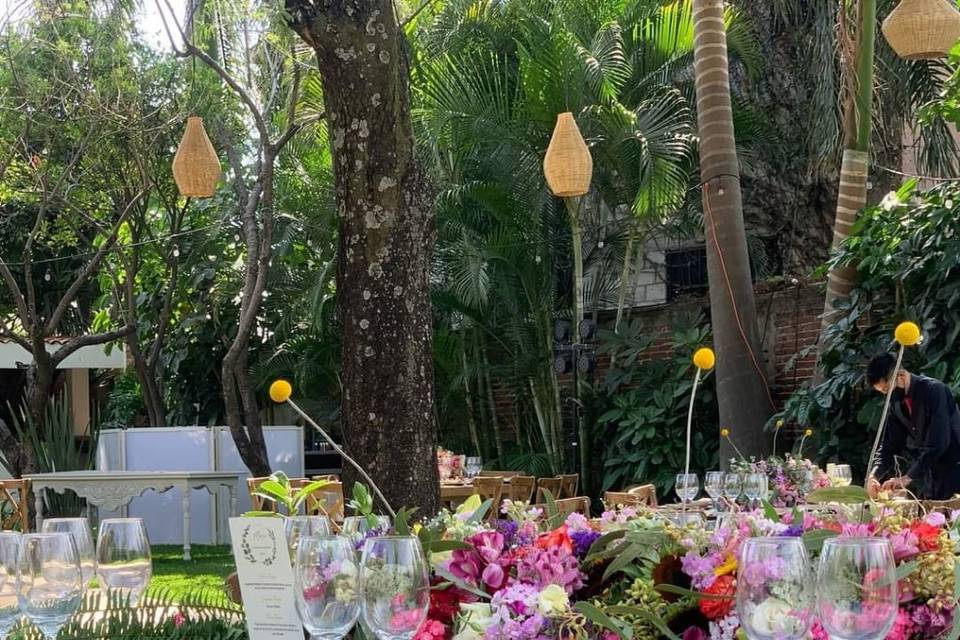 Mesa de madera con copas de cristal con flores de colores