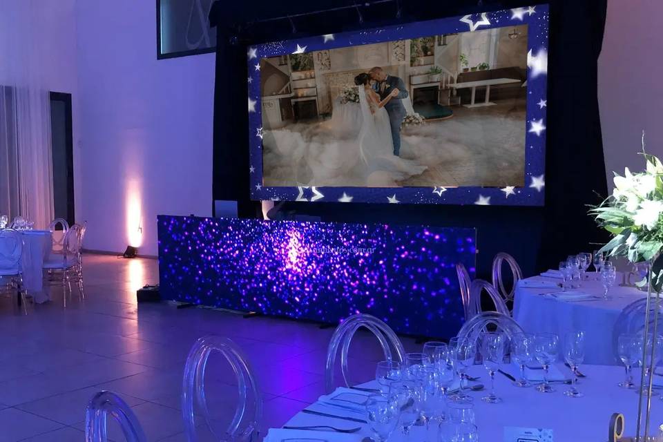 Foto en una pantalla gigante de los novios bailando