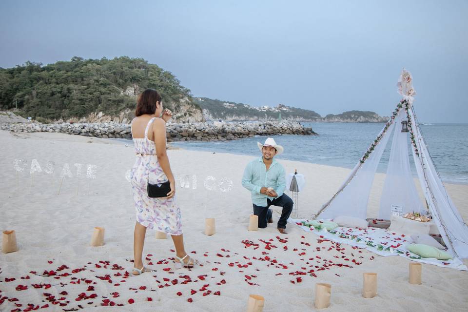 Novios en la playa en propuesta de matrimonio
